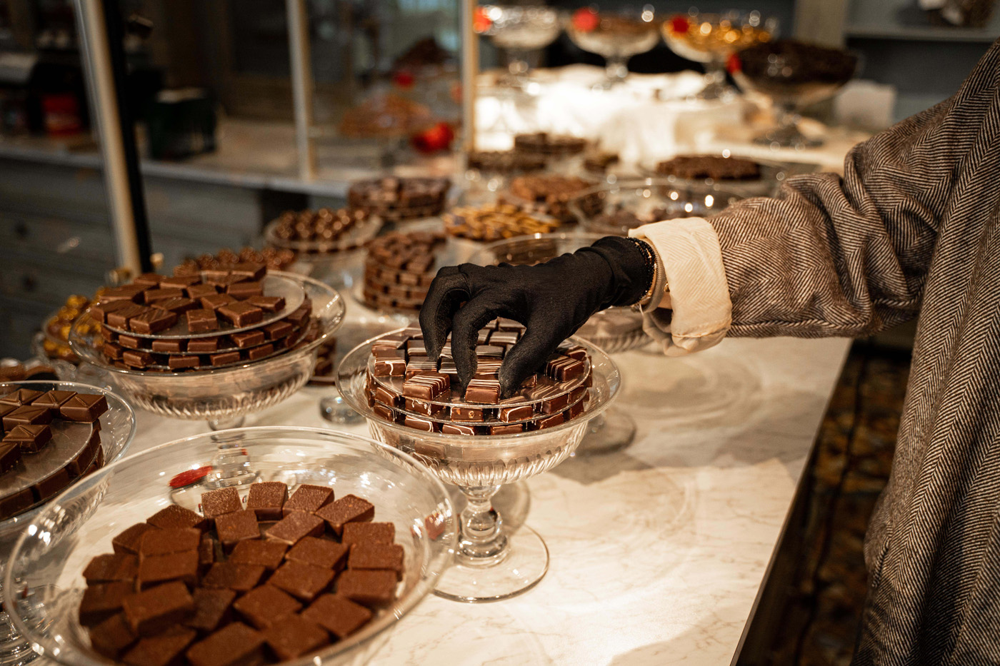 Main disposant des chocolats dans la boutique Duceau